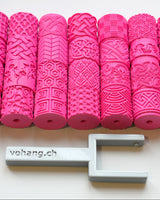 Texture roller for pottery with handle on a white surface, showing pattern detail