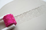 Close-up of the roller head with raised pattern, ready for ceramics