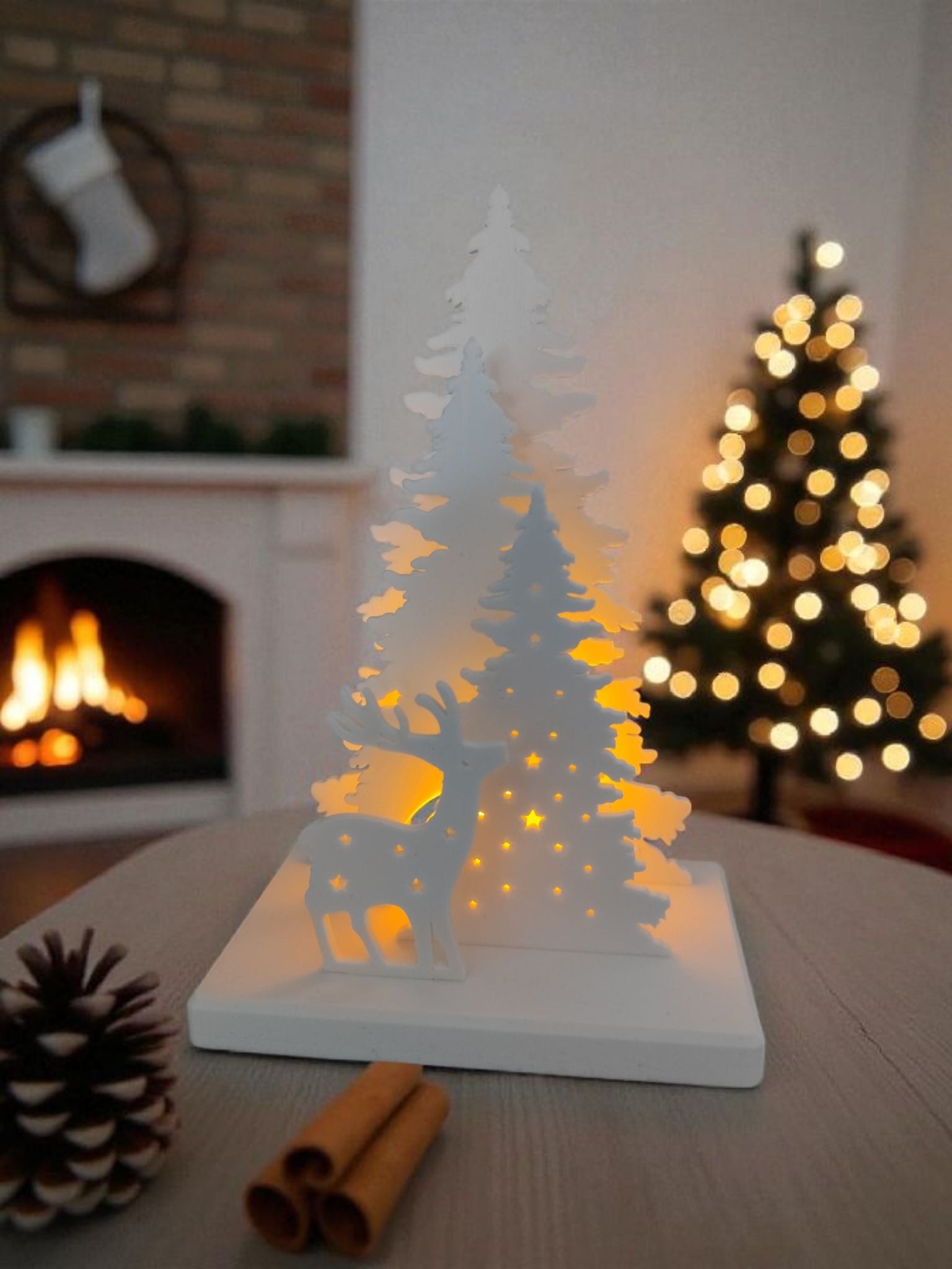 Illuminated Christmas scene with LED tealight holder glowing softly on a white shelf