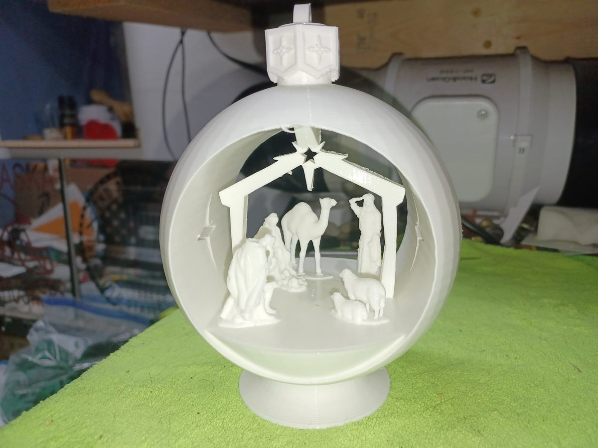 Ball-shaped nativity scene with camel, sheep and stars