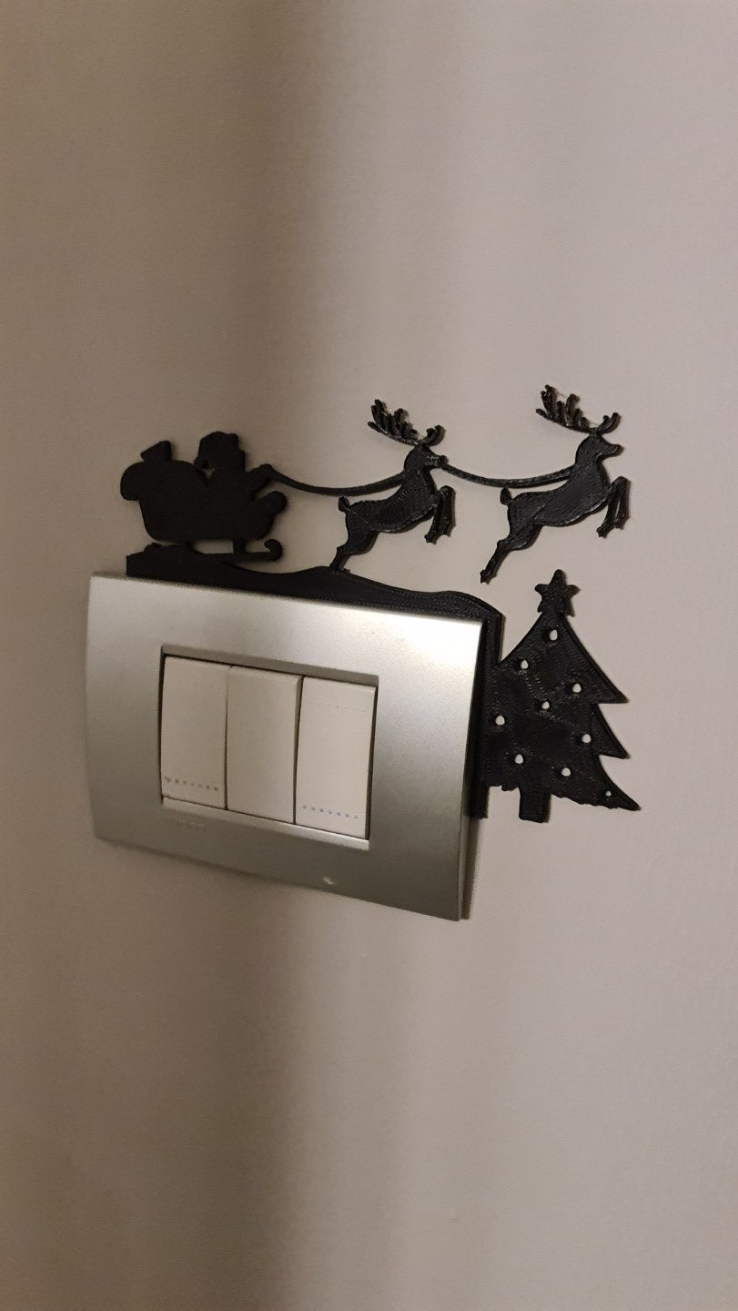 Santa in a sleigh with reindeer as a silhouette above a power socket