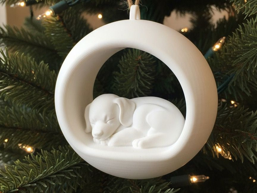 Round Christmas bauble with a sleeping puppy