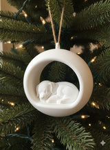 Round Christmas bauble with a sleeping puppy