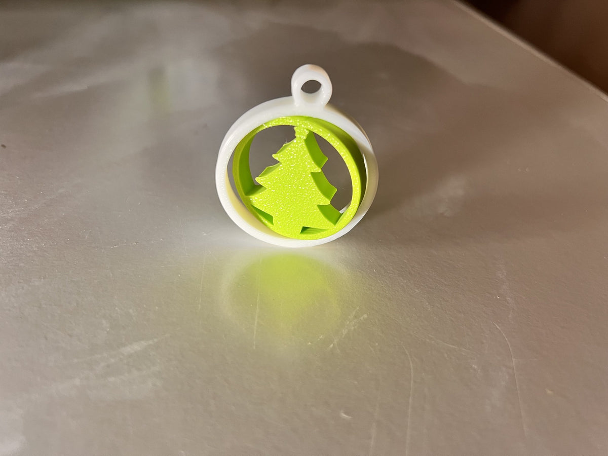 Green Christmas tree in a white ring as a tree ornament
