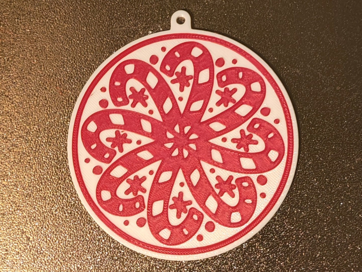 Round Christmas tree ornament with candy canes forming a snowflake