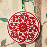 Round Christmas tree ornament with candy canes forming a snowflake