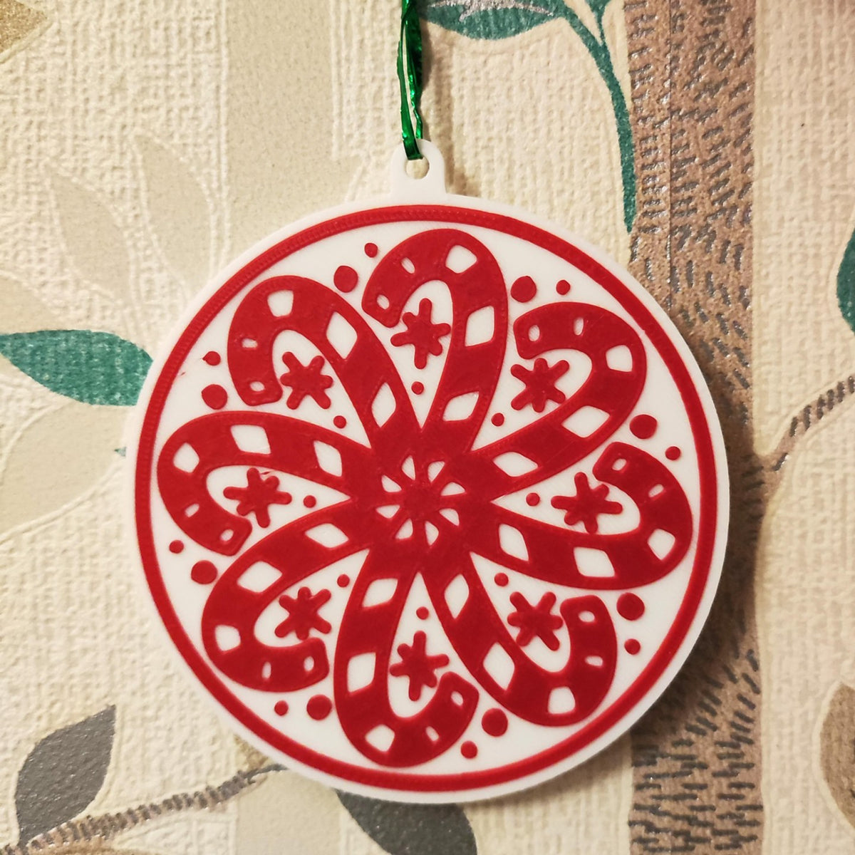 Round Christmas tree ornament with candy canes forming a snowflake