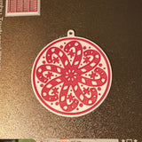 Round Christmas tree ornament with candy canes forming a snowflake