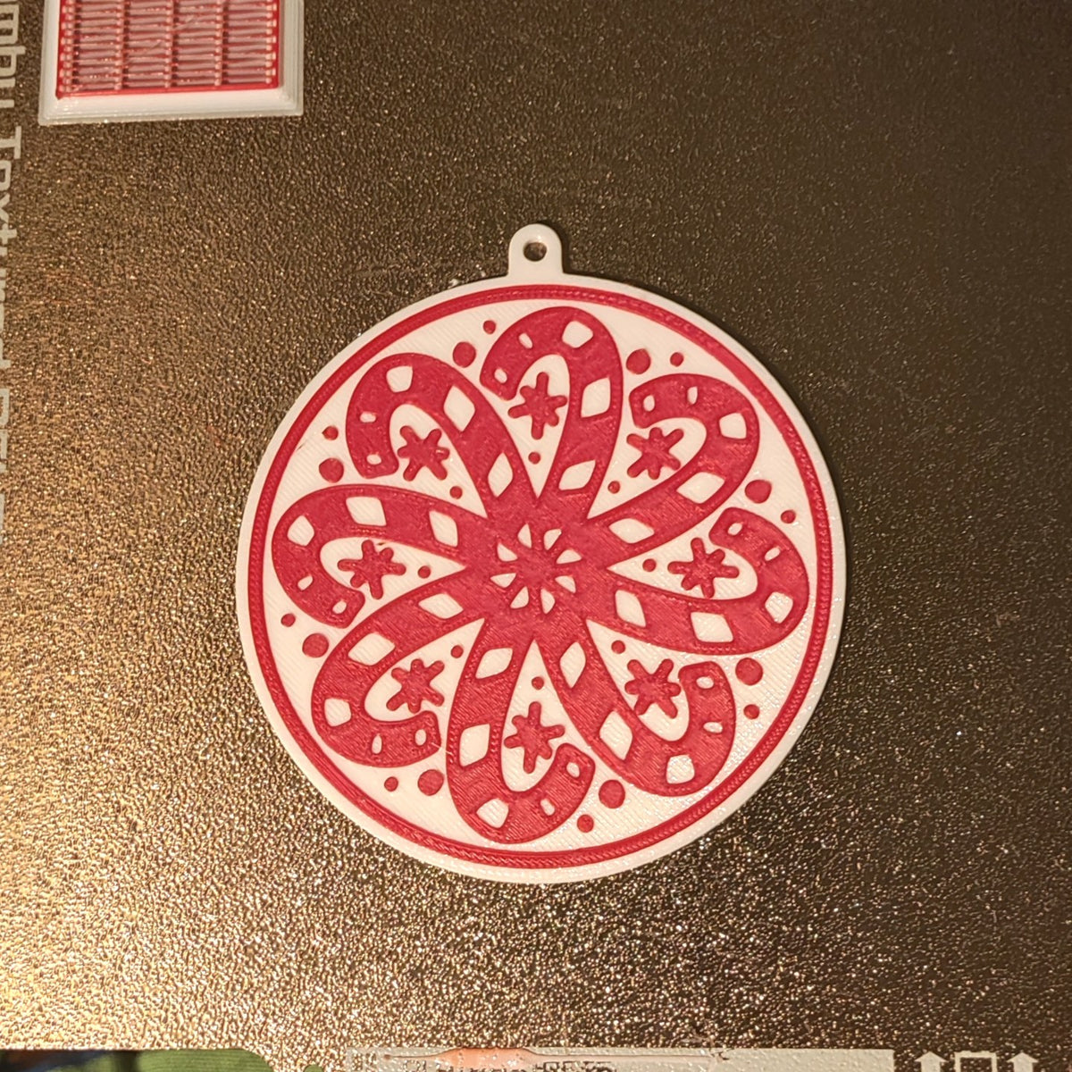 Round Christmas tree ornament with candy canes forming a snowflake