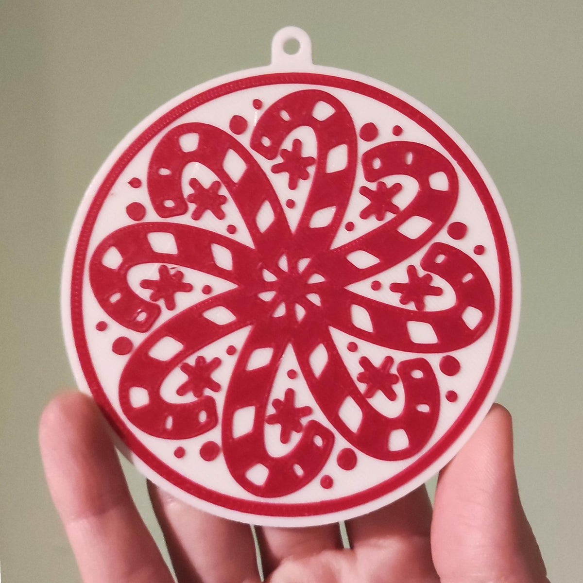 Round Christmas tree ornament with candy canes forming a snowflake