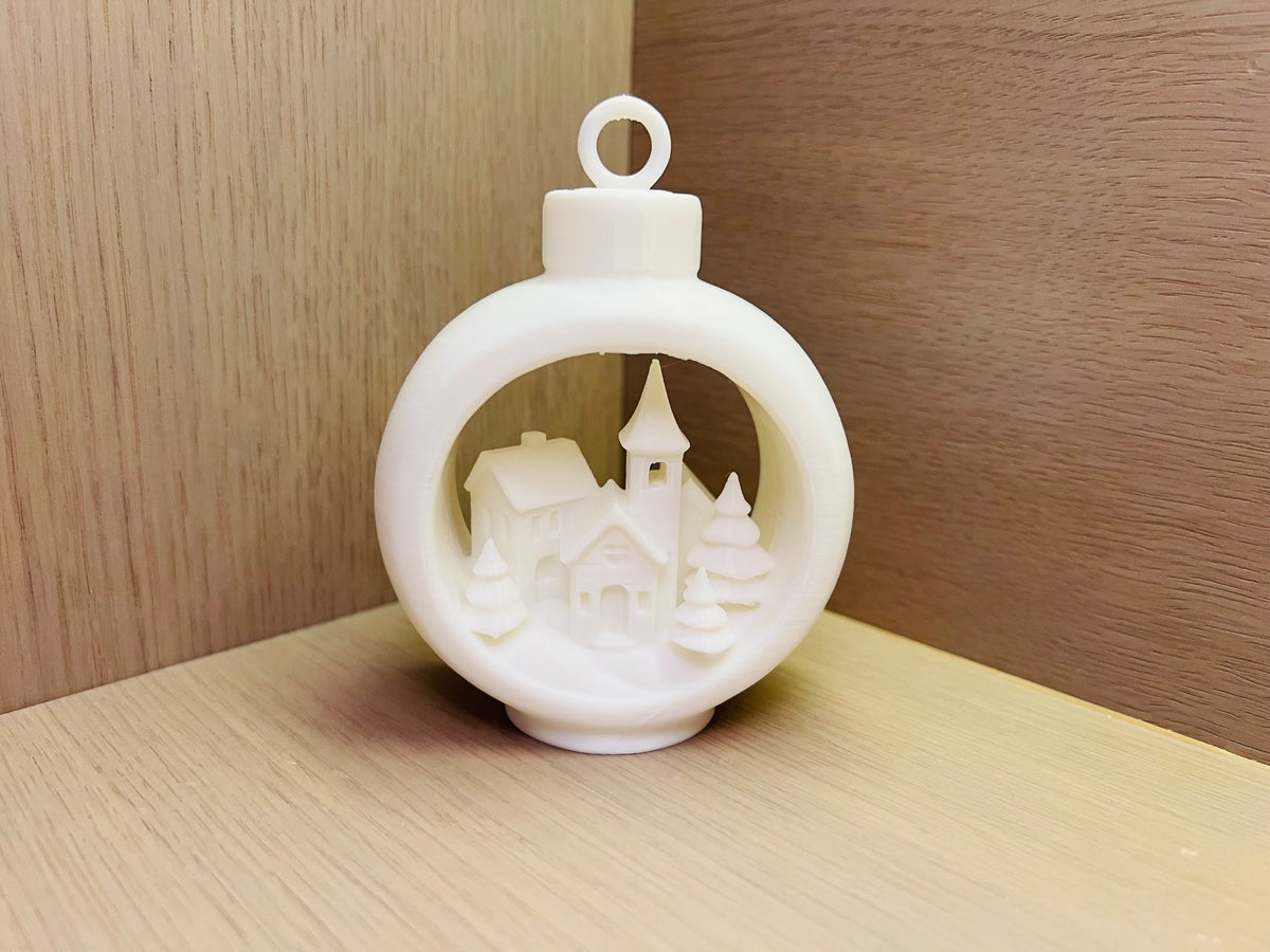 Christmas tree ornament with winter village in a round frame