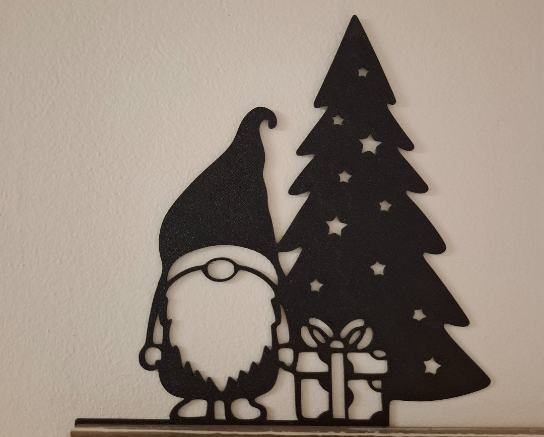 Christmas gnome figure with a present by the Christmas tree
