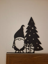 Christmas gnome figure with a present by the Christmas tree