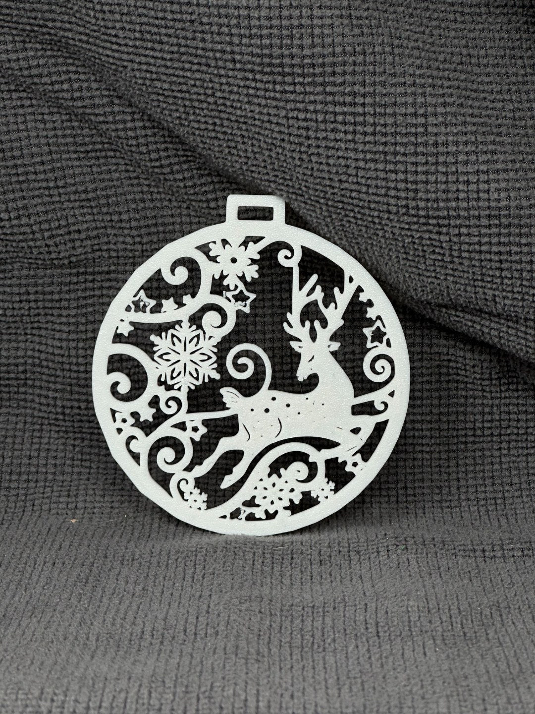 Round Christmas tree ornament with flying reindeer and snowflakes