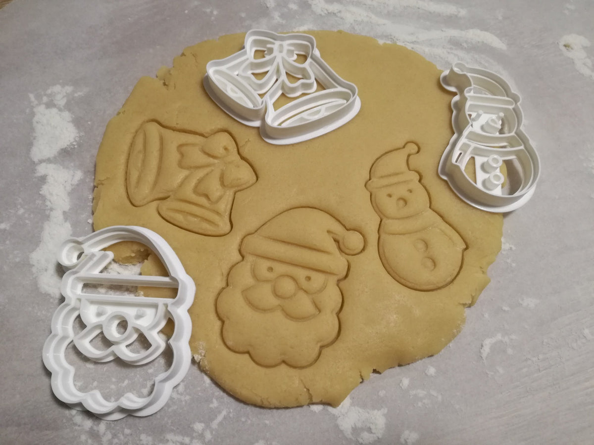 Three cookie cutters: Santa Claus, snowman and Christmas bells