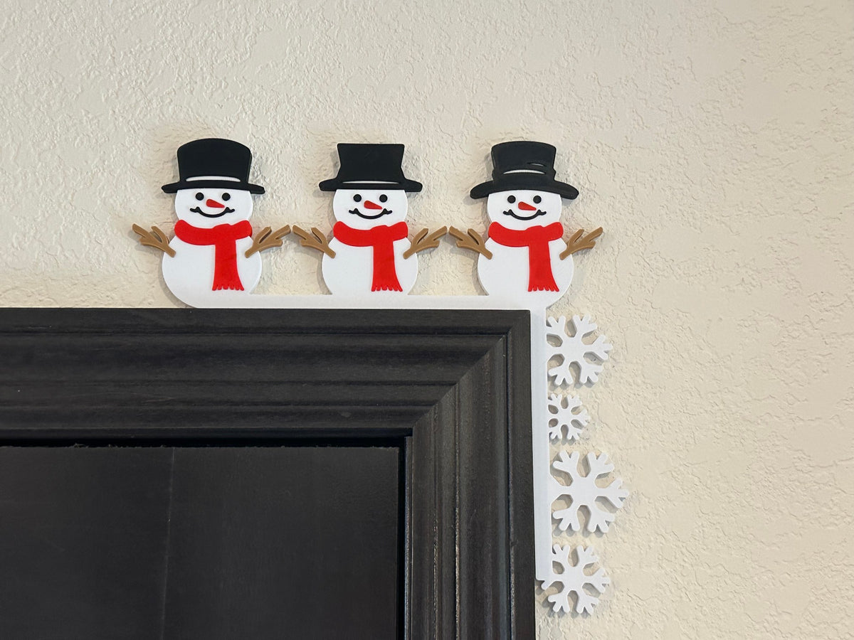 Snowmen and snowflakes decorating the corner of a door frame