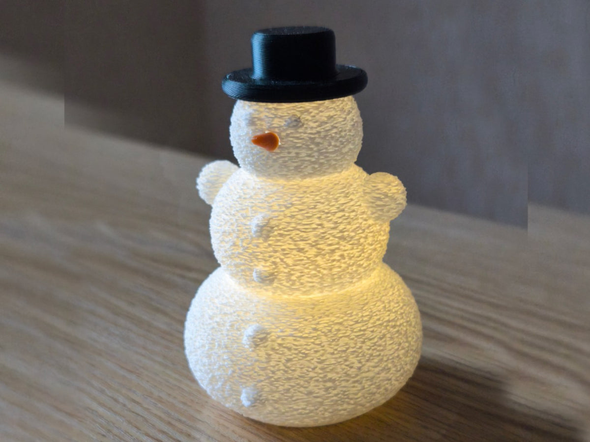 Snowman with hat and nose over an LED tealight