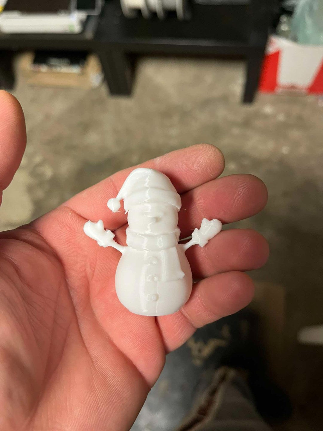 Snowman figure with scarf, mittens and hat